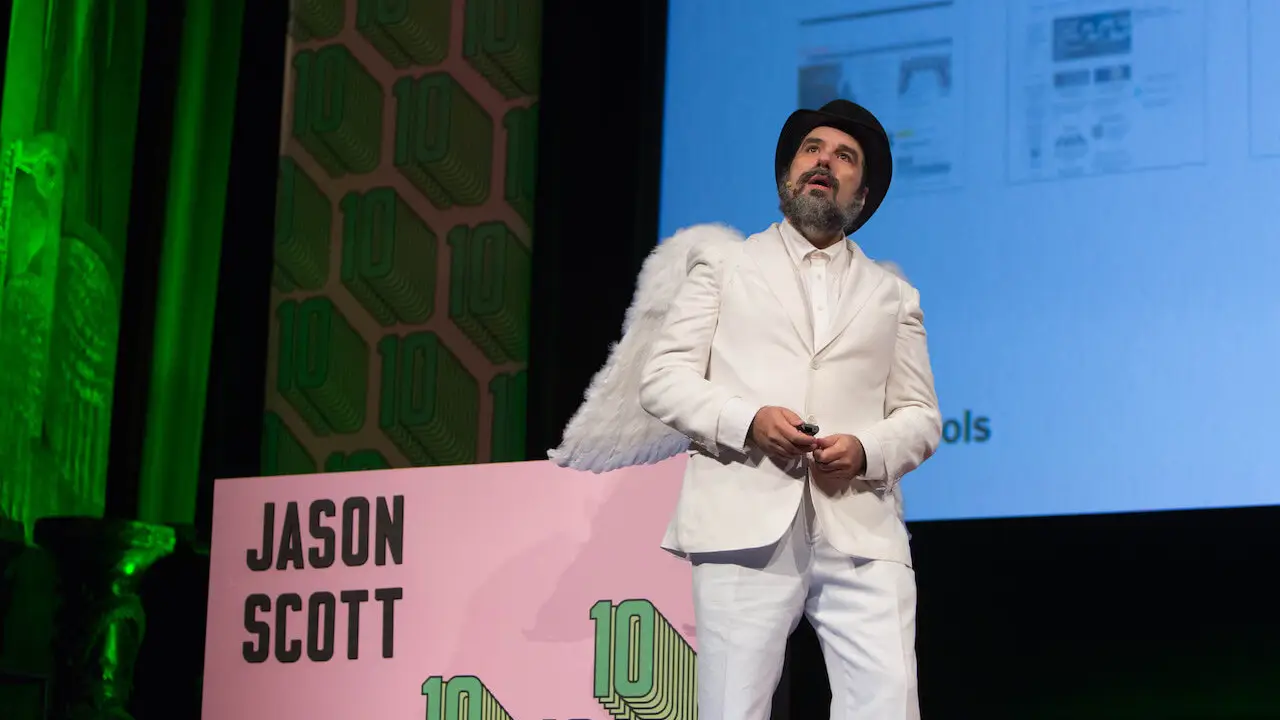 An enigmatic conference speaker, wearing a white suit, top hat and angel wings